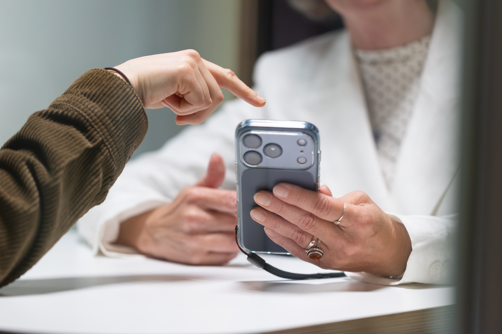 Person shows other person usage of Data4Lifes D4L Collect App on smartphone.